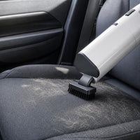 Aspirador inalámbrico limpiando pelo de mascota del asiento del coche